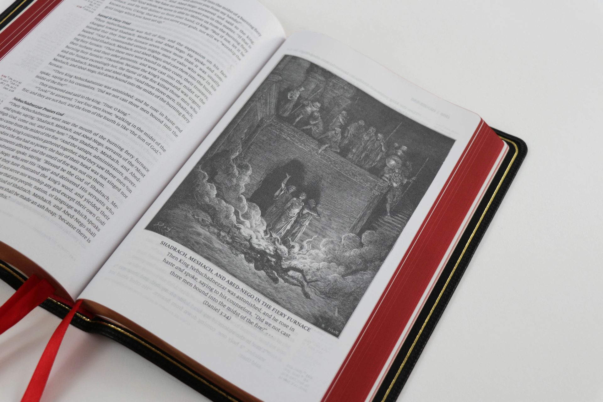 an open book with a red ribbon around it