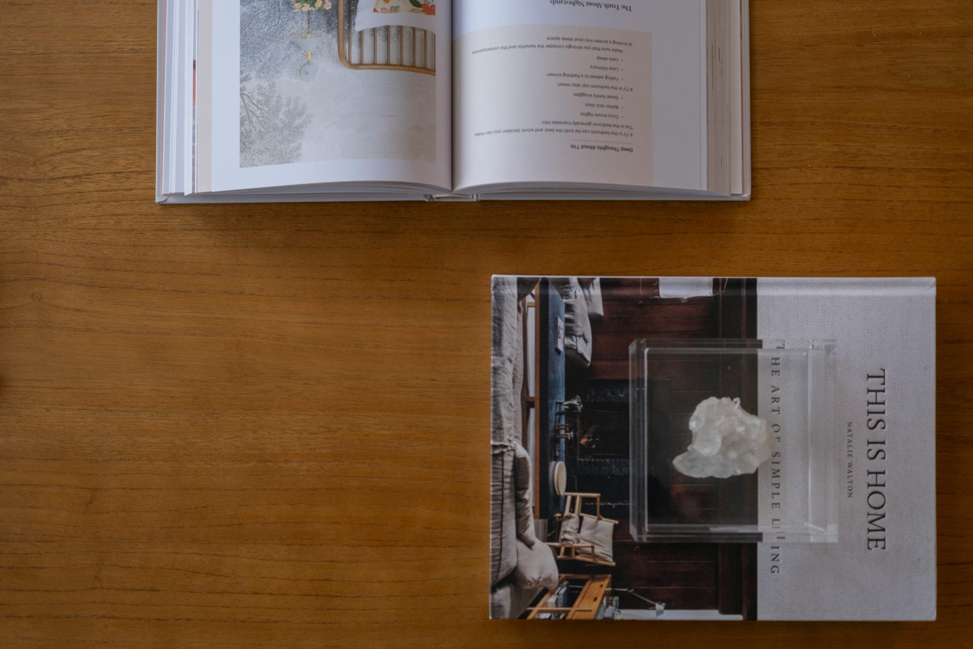 Two books placed on a wooden table.